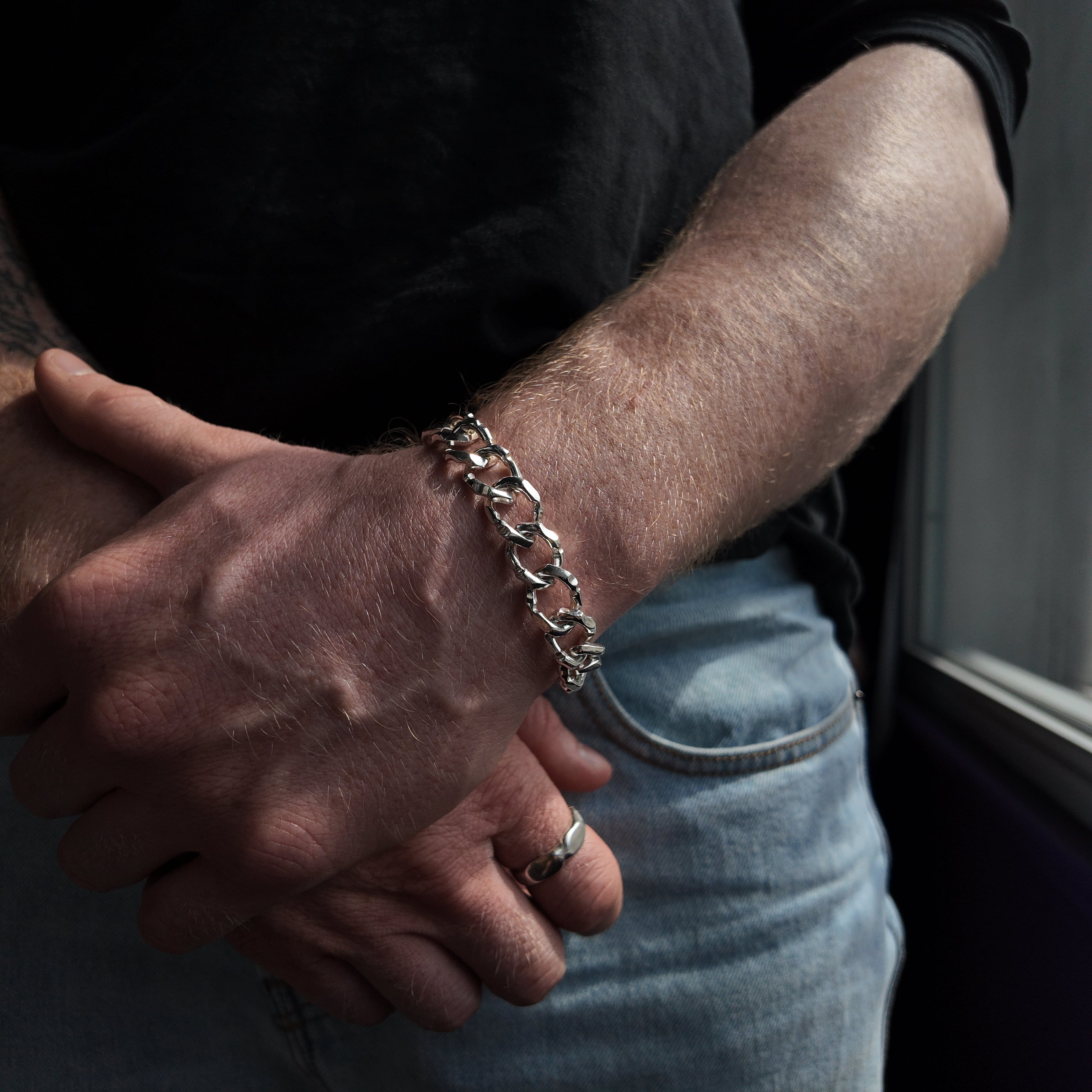 Carved medium silver bracelet handshot with hand holding wrist