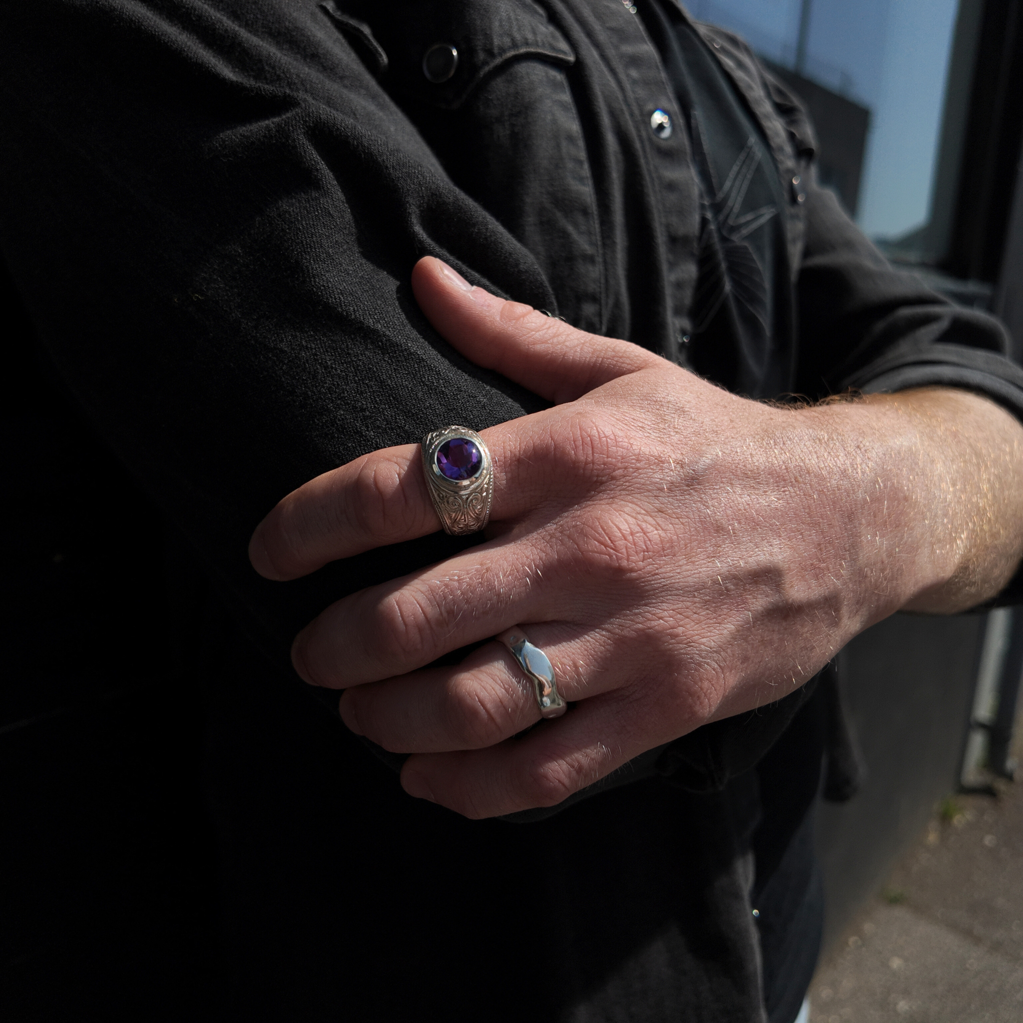 silver gun engraved college signet ring with amethyst on hand