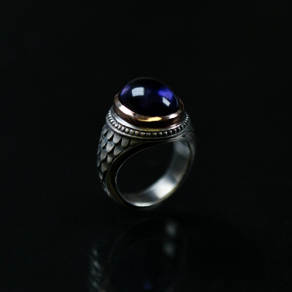 This silver college style ring is handmade in solid silver with a 9ct rose gold setting and oval cabochon amethyst.
