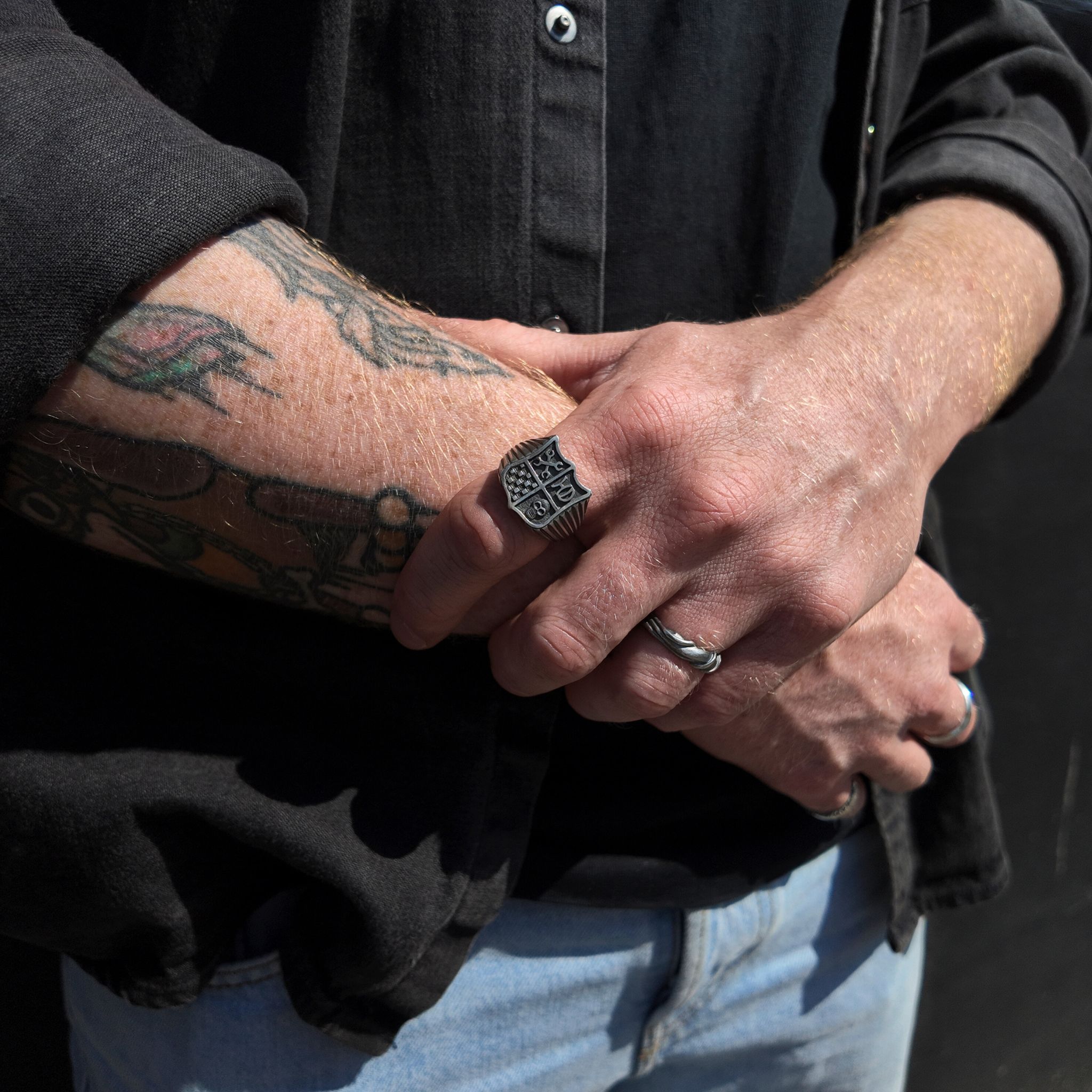 Hoye Division shield signet ring on hand with hand holding wrist