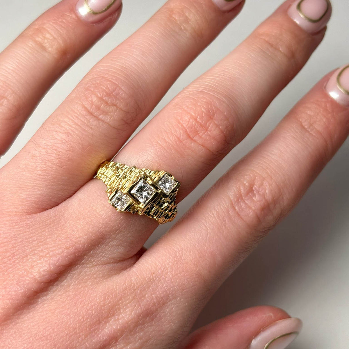 This unique ring holds three diamond, the centre stone holds a 40pts diamond and two either side holds .18pts.