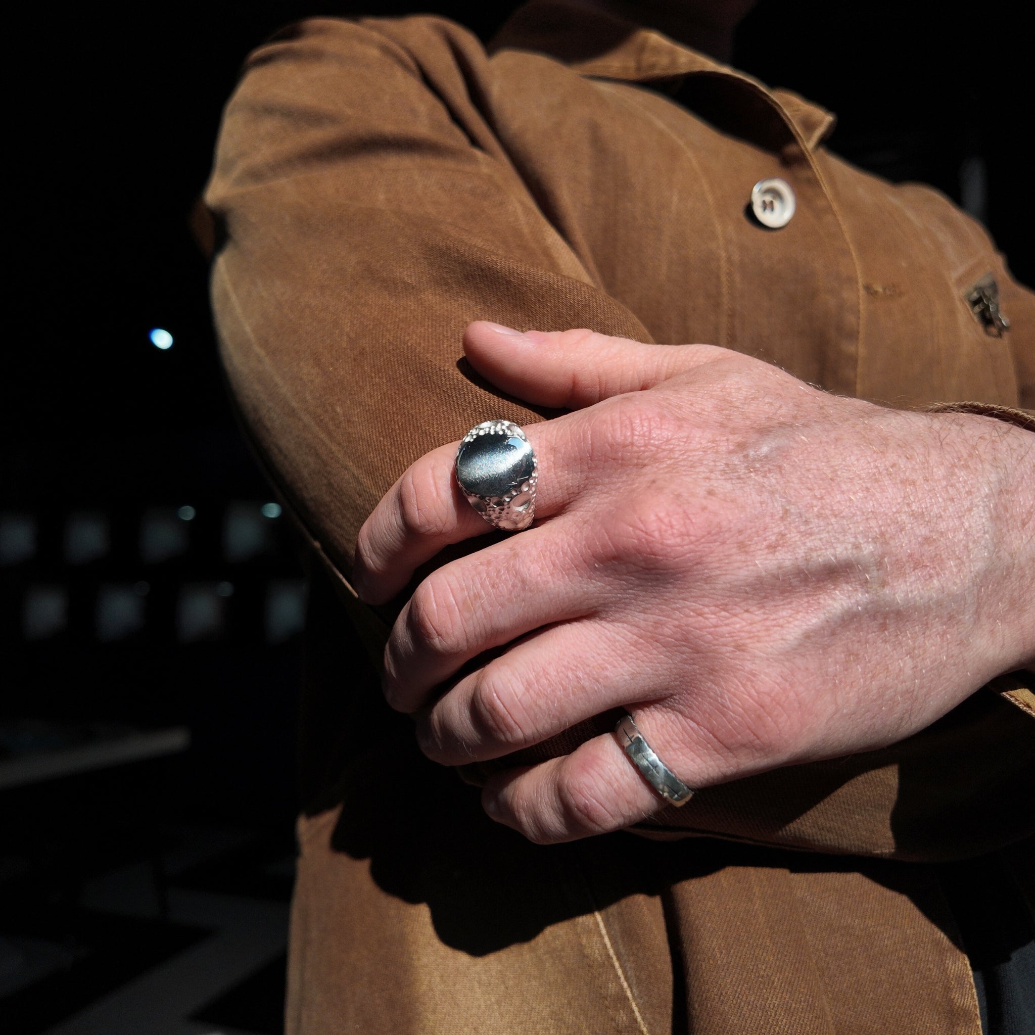 Moon Large silver signet ring on hand with hand holding opposite arm