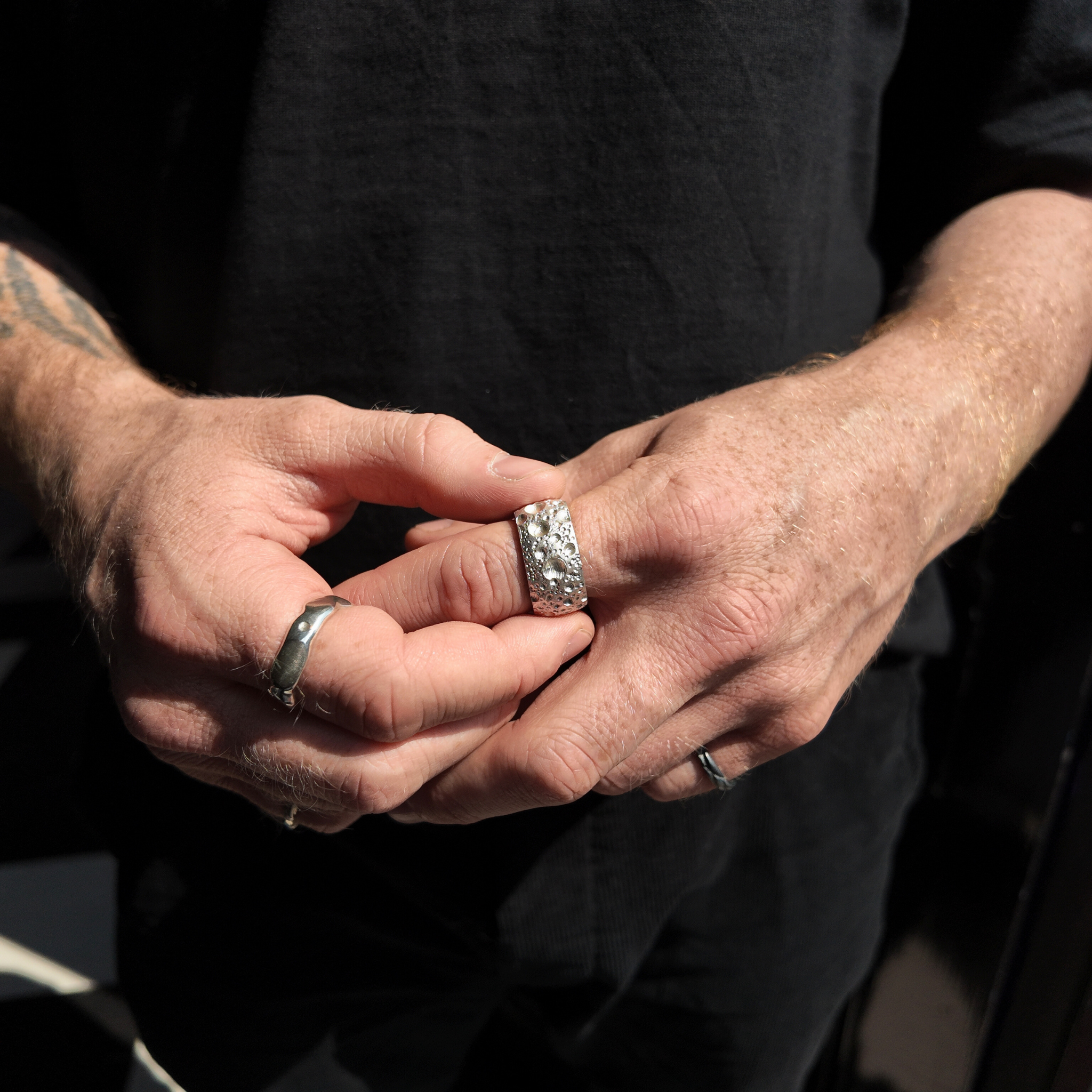 moon silver 12mm ring handshot with man holding ring on finger