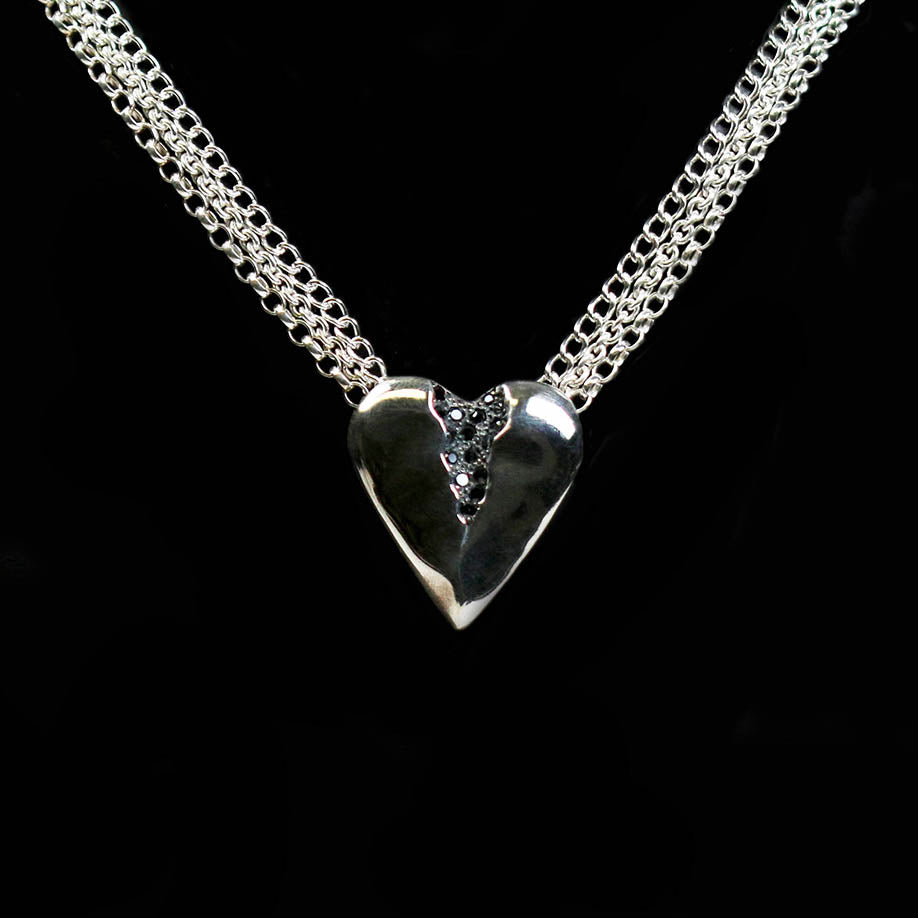 This beautiful heart pendant which is pavé set with 16 tiny black cubic zirconia. The piece hangs elegantly on a 16" multi-strand chain.