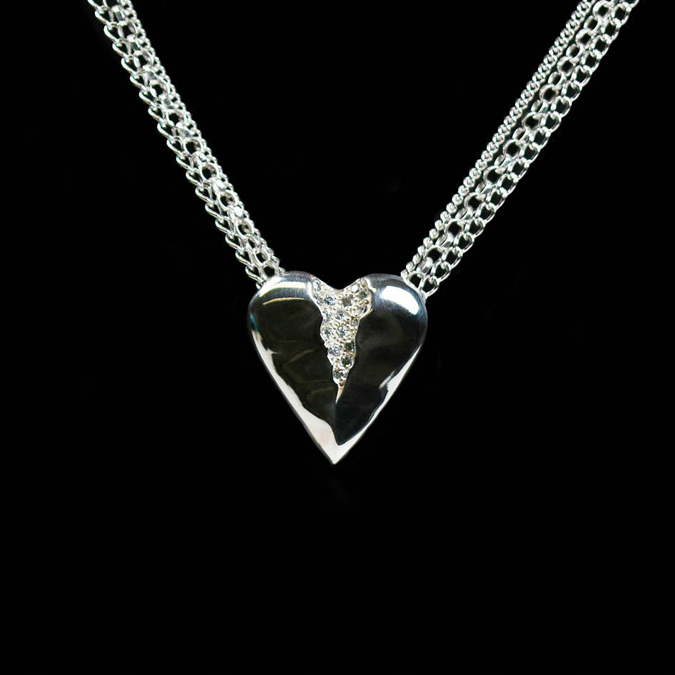 This beautiful heart pendant which is pavé set with 16 tiny cubic zirconia. The piece hangs elegantly on a 16" multi-strand chain.