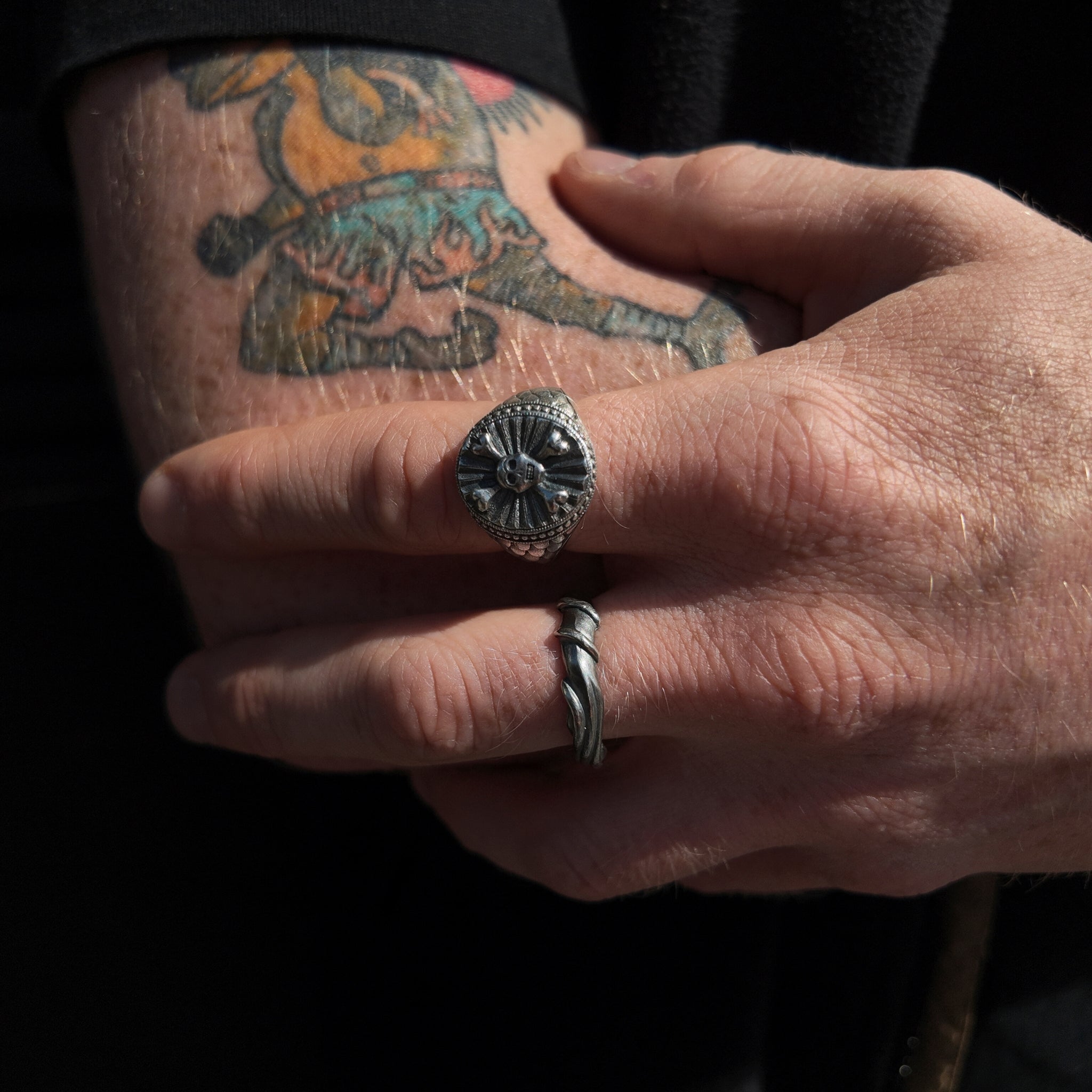 hoye division skull and crossbones signet ring on hand macro shot