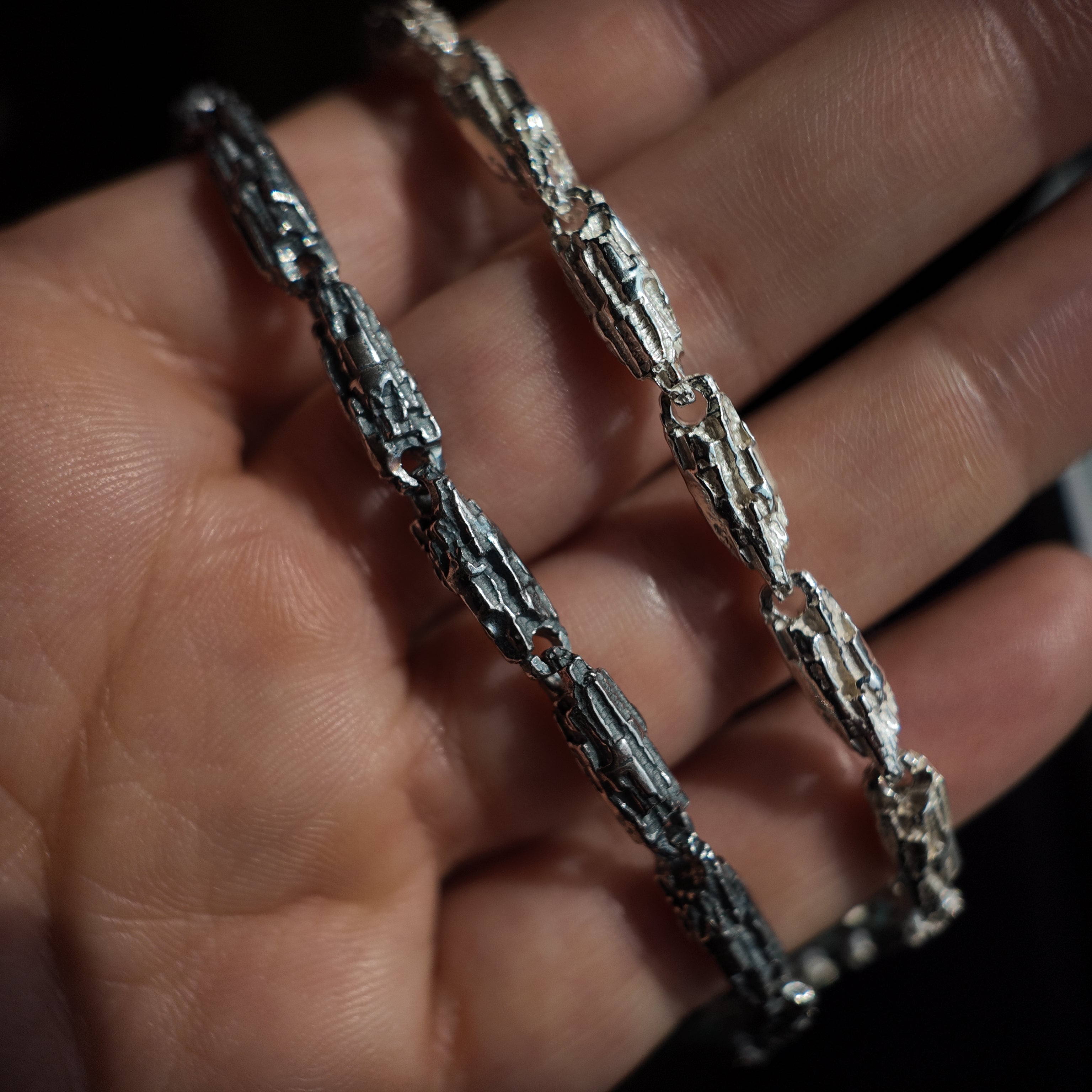 hand holding an oxidised and polished finish Luna silver bracelet
