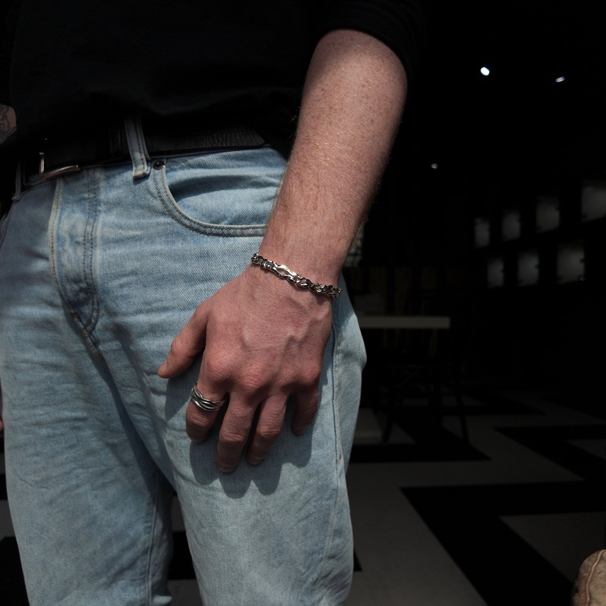 Carved long link bracelet with a polished finish worn on the wrist