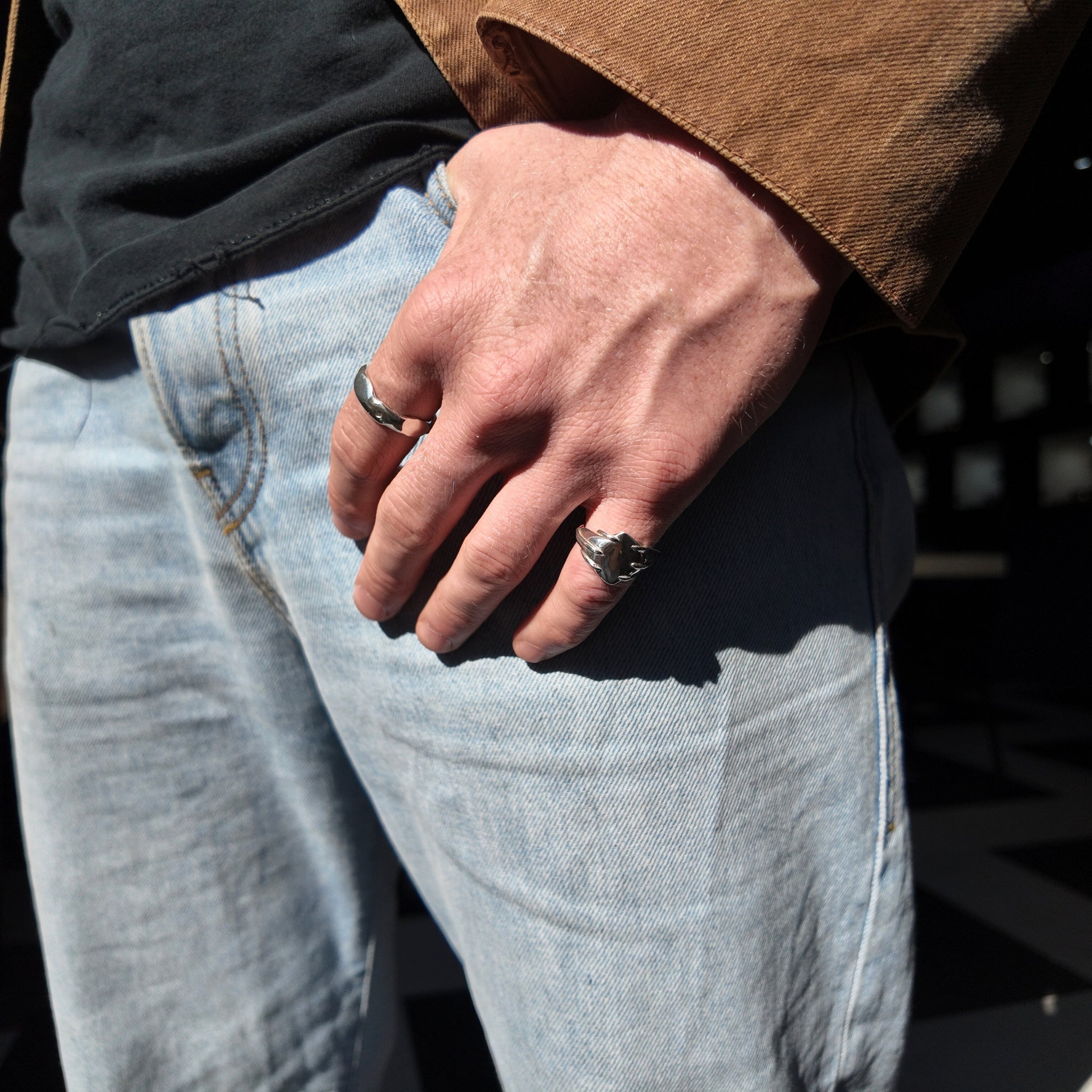 Entwine small signet ring on mans hand with thumb in pocket