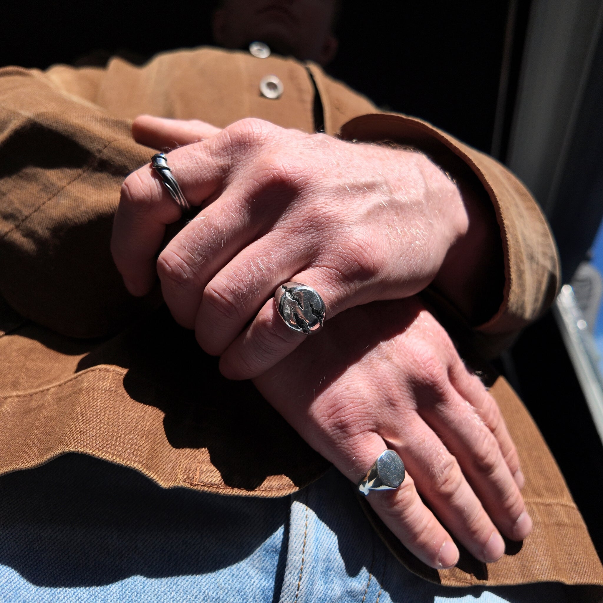 Slashed small silver signet ring oxidised finish on mans hand