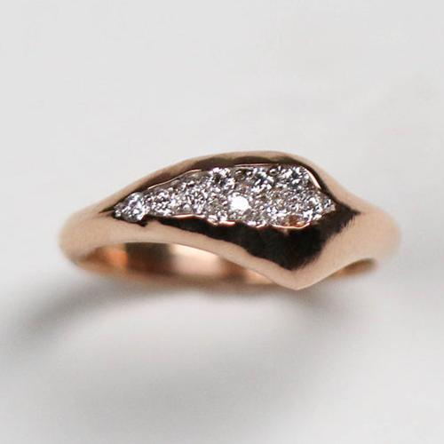 Designed so it sits off-centre for an asymmetric look, the band tapers from 7.5mm to 2.75mm in width. Inspired by crystal geodes, this ring is pavé set with twelve tiny, round, brilliant cut white diamonds which total .40pts of a carat.