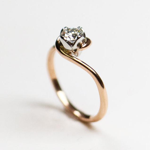 An 18ct rose gold simple, fine band with contrasting four petal setting in platinum. Set with .42pt round, brilliant cut diamond.