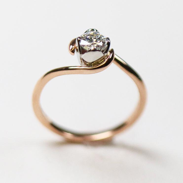 An 18ct rose gold simple, fine band with contrasting four petal setting in platinum. Set with .42pt round, brilliant cut diamond.