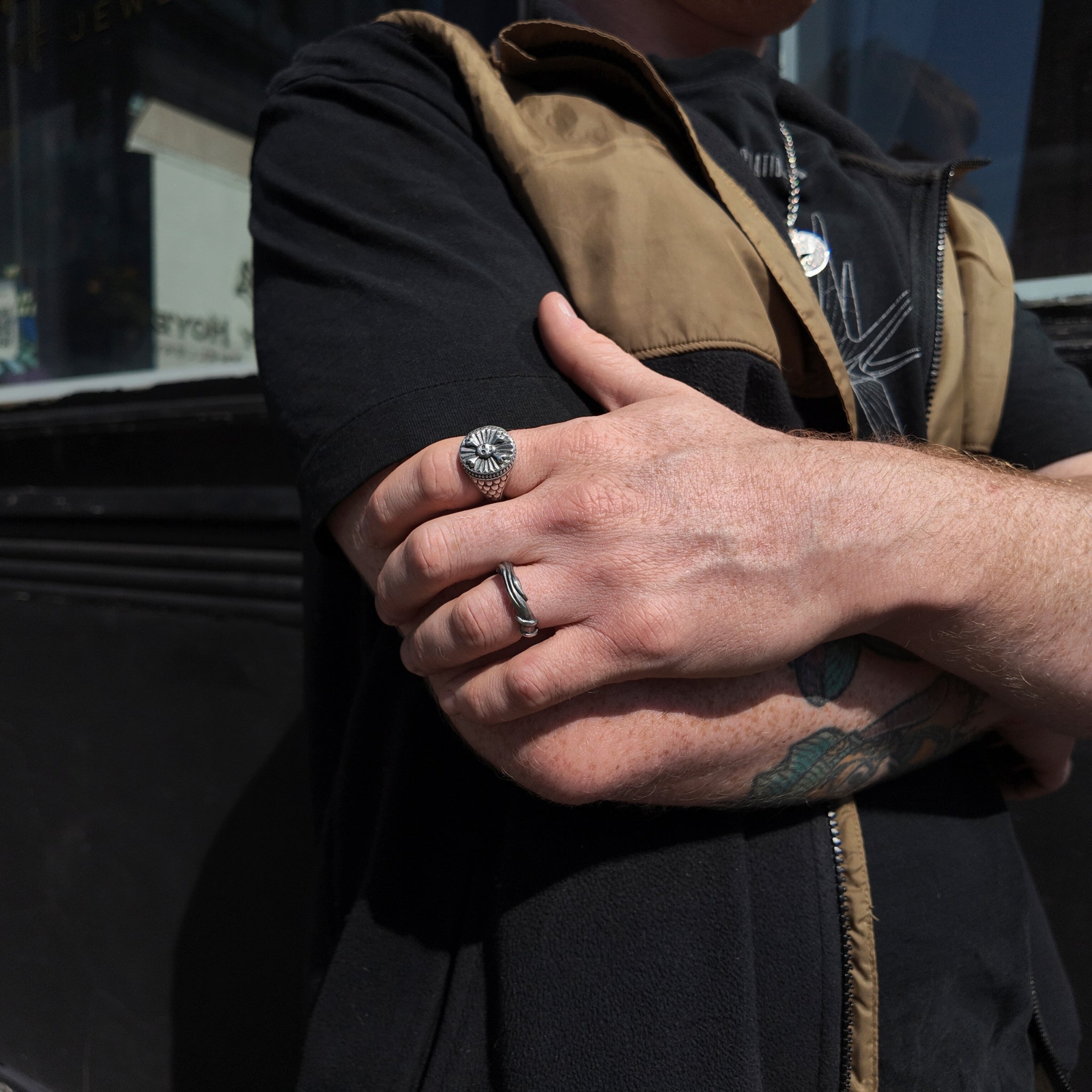hoye division skull and crossbones signet ring on hand - hand holding arm