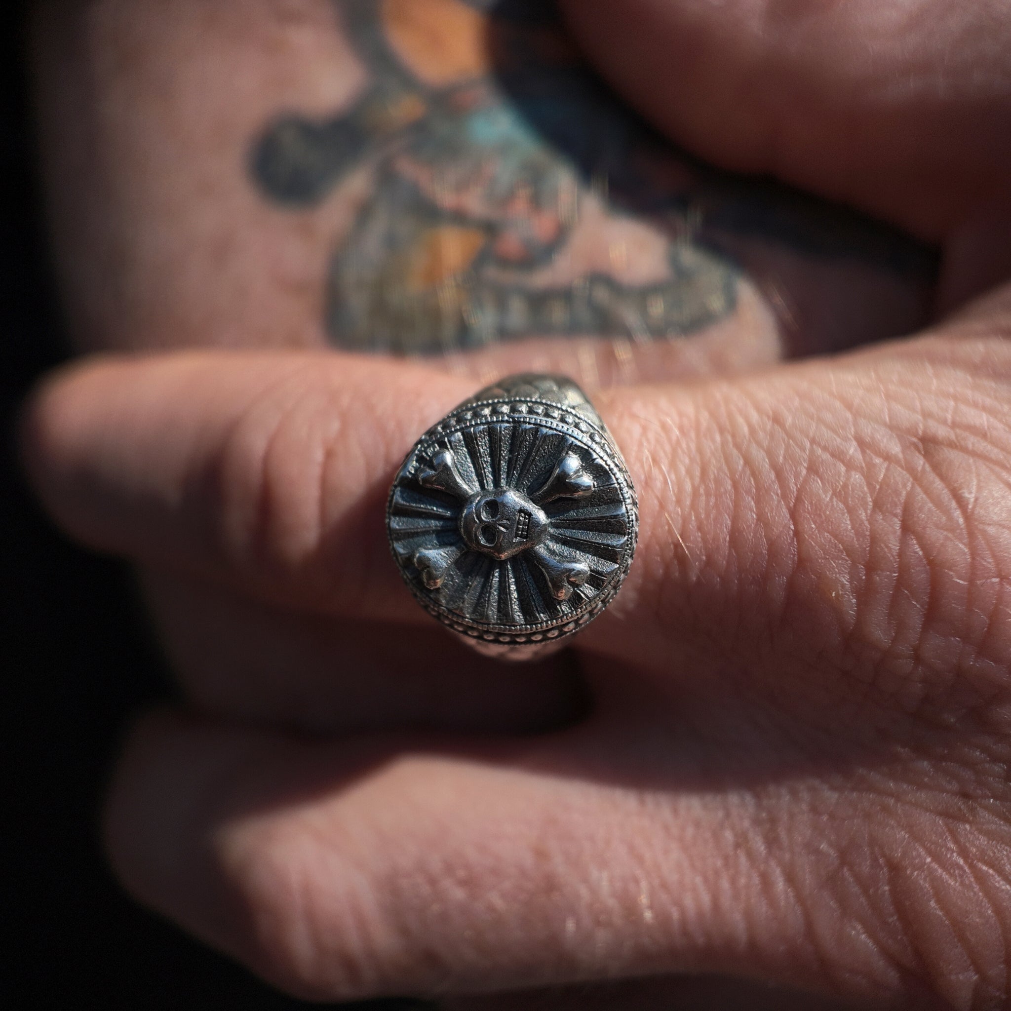 hoye division skull and crossbones signet ring macro shot on finger
