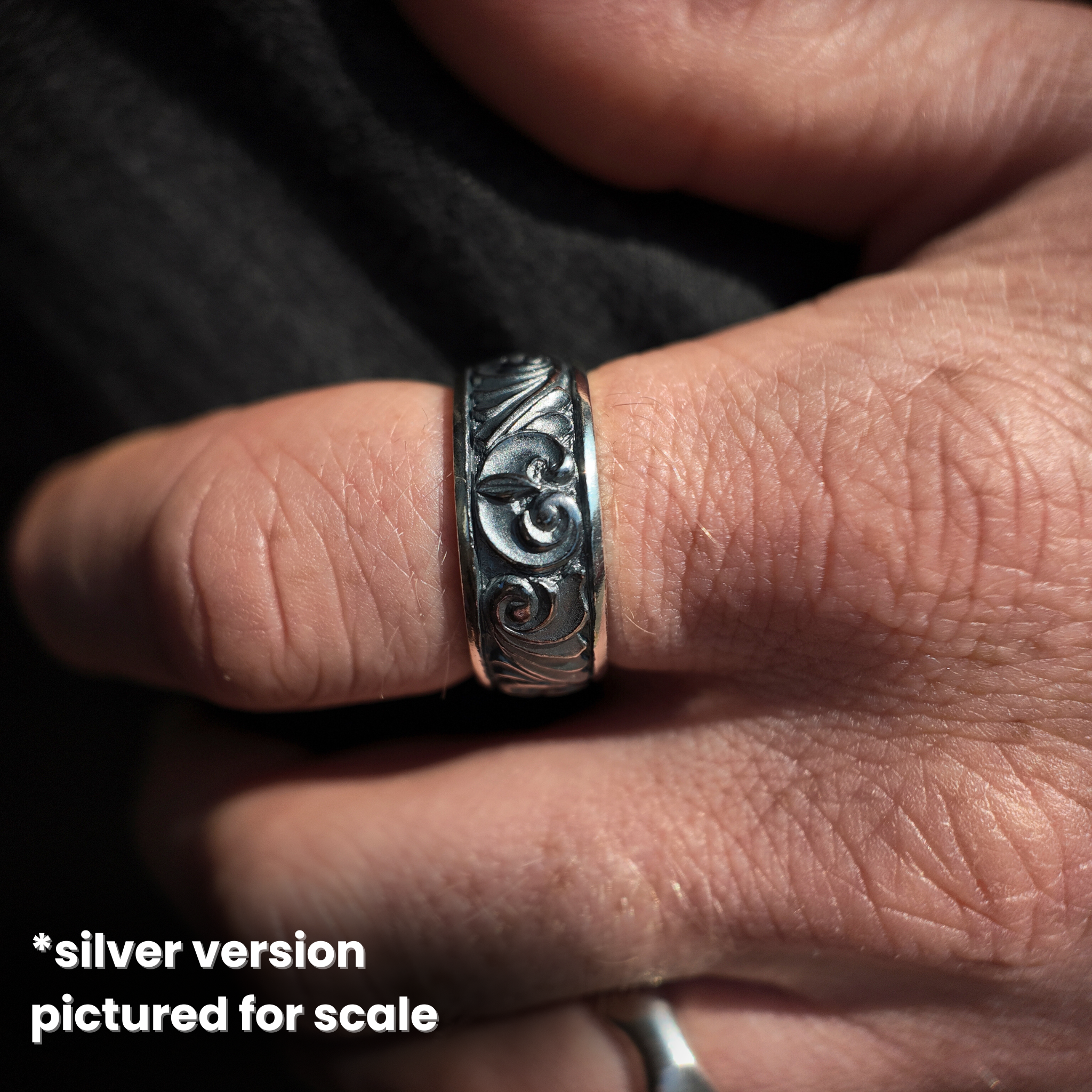 silver gun engraved ring (for gold) macro shot on hand 