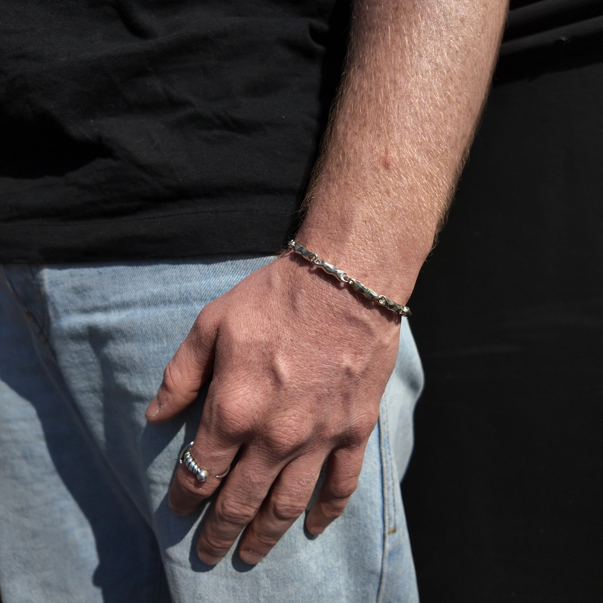 wave collection silver link bracelet on wrist with hand by side